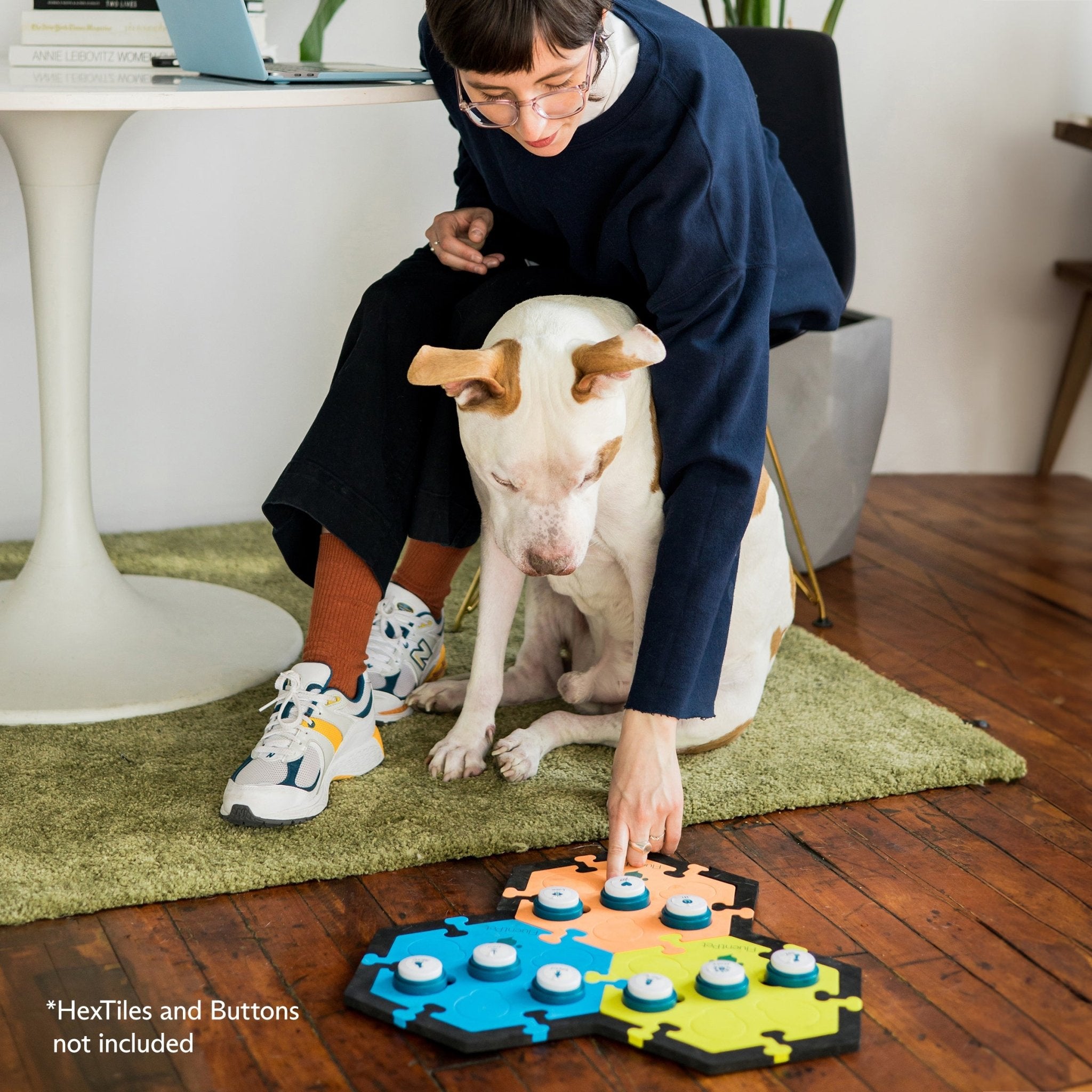 A young woman teaching her dog to talk with FluentPet buttons and HexTiles