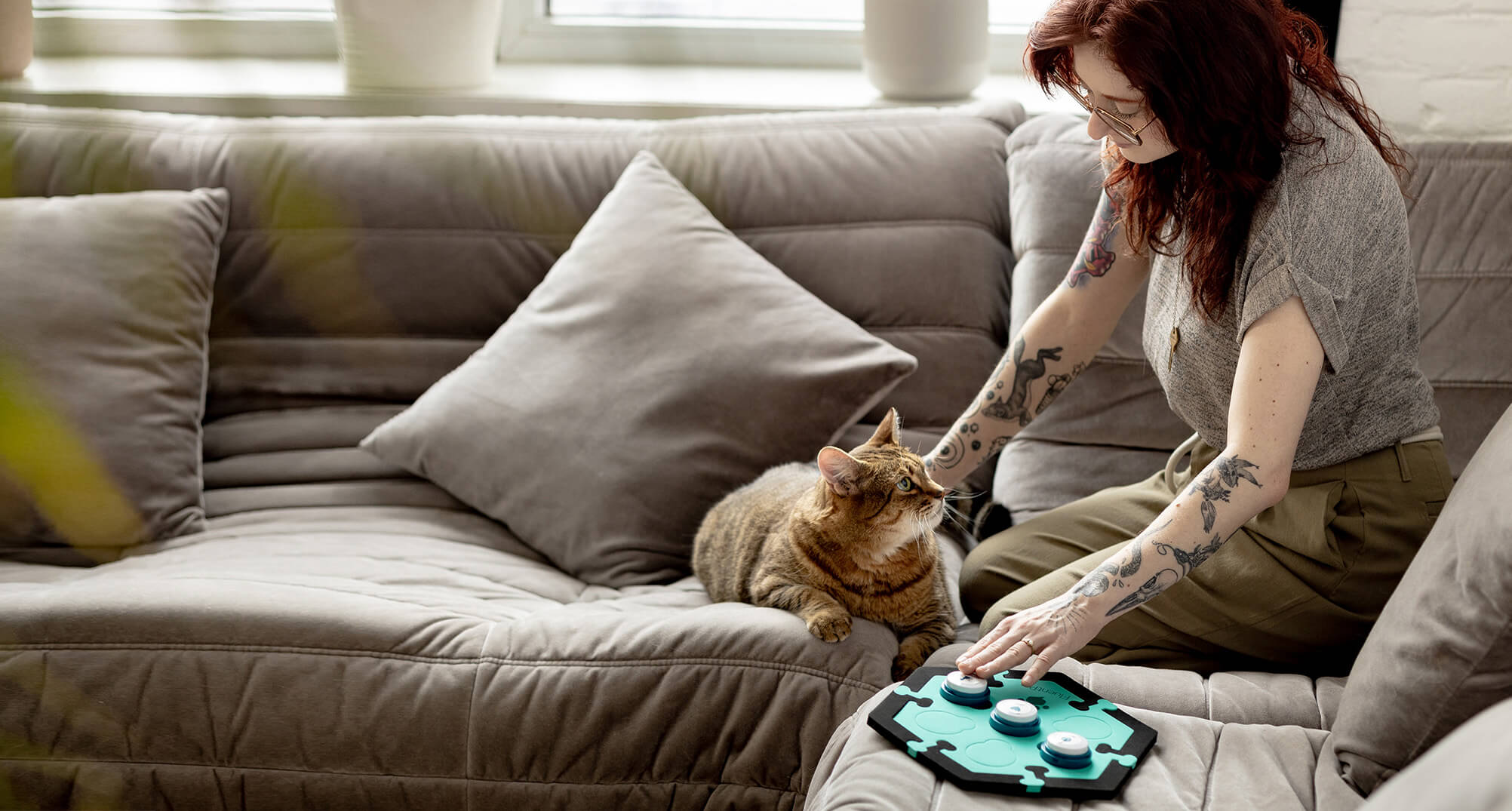 Women showing her cat how to use cat talking buttons