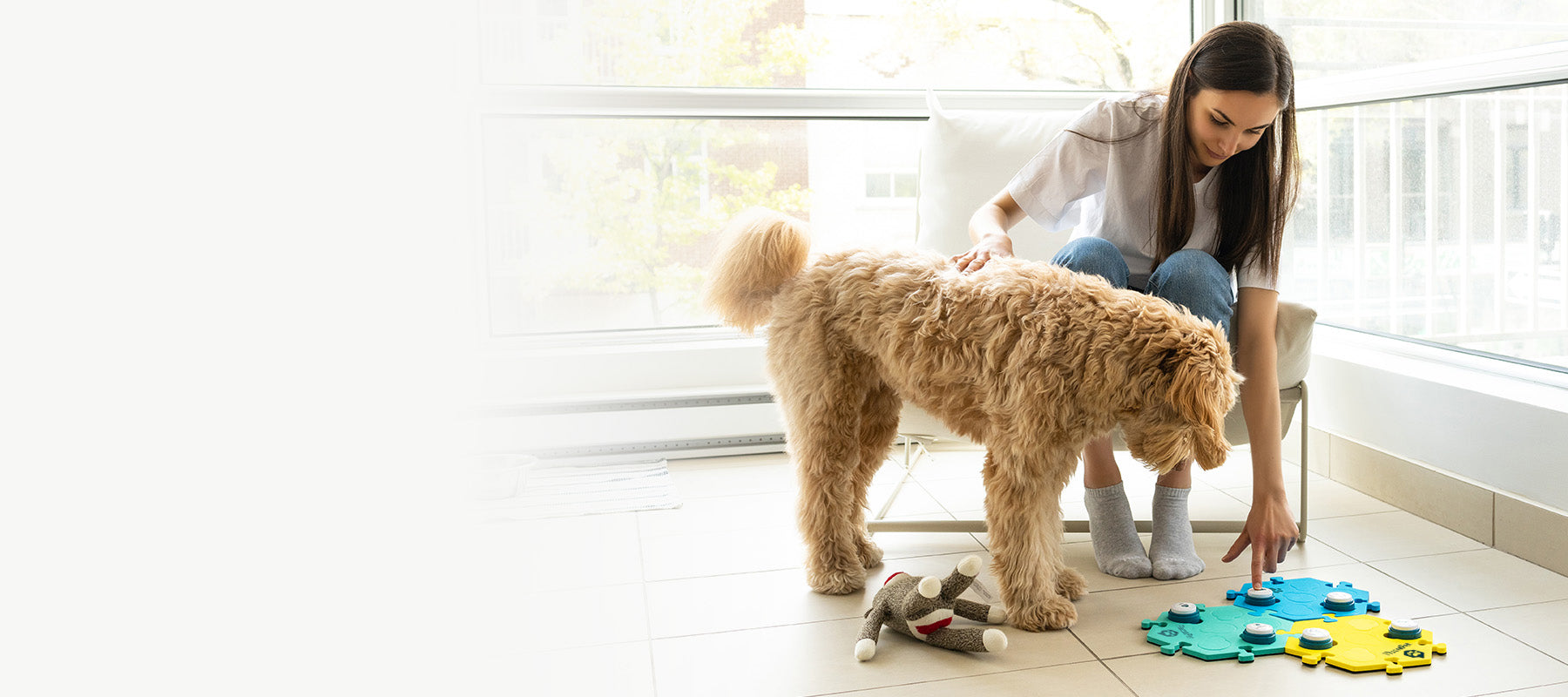 A woman and her dog using the FluentPet Get Started Kit with recordable sound buttons.