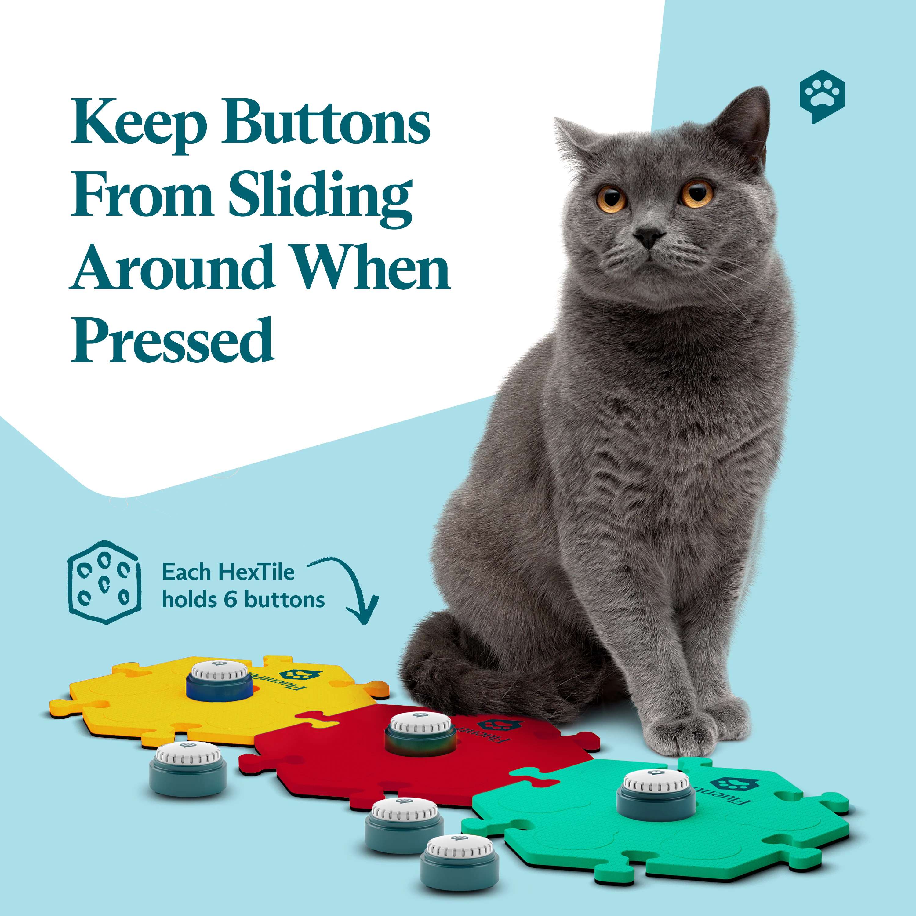 Gray cat sitting beside FluentPet HexTiles in red, yellow, and teal, each holding recordable Speak Up! buttons from the FluentPet Speak Up! Get Started Kit; text reads “Keep Buttons From Sliding Around When Pressed.